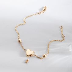 a gold necklace with heart charms on it