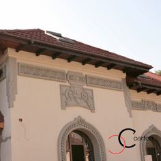 a building that has a clock on the top of it's roof and windows