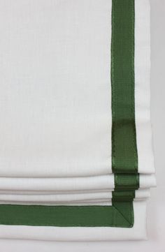 three folded white and green napkins on top of each other