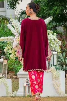 Elegant and sophisticated, this crimson shade is cut from the softest velvet into an effortless box-cut silhouette. The kurta is worked with embroidered floral patterns, embellishments and finished with scalloped edges. The cut out neckline and heavily embellished cuffs on the sleeves offset the piece beautifully. The Party Kurta With Embroidered Long Sleeves, Elegant Silk Kurta With Embroidered Sleeves, Fitted Velvet Dresses For Designer Wear, Velvet Fitted Dress For Designer Wear, Velvet Dress With Traditional Drape For Designer Wear, Festive Velvet Long Sleeve Sets, Eid Party Kurta With Embroidered Sleeves, Elegant Straight Kurta With Embroidered Sleeves, Bollywood Velvet Sets With Long Sleeves