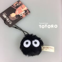 a black fuzzy ball with eyes and a tag attached to it