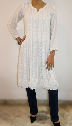 Experience the timeless elegance of our A-line 8 Kali panel tunic, a masterpiece of artisanal craftsmanship. This tunic, with its split neckline and full sleeves, exudes a blend of tradition and contemporary charm. The entire front and back are adorned with intricate chikankari hand embroidery, showcasing delicate patterns that tell a story of meticulous dedication. The hem is gracefully finished with hand-crocheted edges, adding a touch of vintage allure. With a length of 38 inches, this tunic offers both style and comfort, making it a versatile addition to your wardrobe. length - 38 inches Sizes -  S - fits bust 34 M - fits bust 36 L - fits bust 38 XL - fits bust 40 0X - fits bust 42 1X - fits bust 44 Prewashed. Preshrunk. Requires normal machine wash and line dry with light ironing for Elegant V-neck Tunic For Fall, Elegant Fall V-neck Tunic, Transitional Long Sleeve Dresses With Resham Embroidery, Long Sleeve Dresses With Resham Embroidery For Transitional Season, Fitted White Kaftan For Transitional Season, Elegant White Kaftan For Transitional Season, Folk Style Long Sleeve Chikankari Dress, Elegant Tunic Kaftan With Embroidered Neckline, Elegant V-neck Festive Tunic