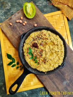 a pan filled with food sitting on top of a wooden cutting board