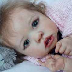 a close up of a baby laying on a bed