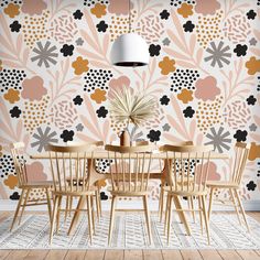 a dining room table with chairs and a vase on top of it in front of a floral wallpaper