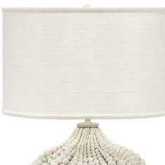 a table lamp with a white shade on the top and beads hanging from it's base