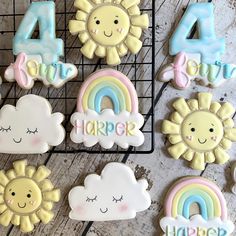 decorated cookies with the number four, sun, and rainbows on top of a cooling rack