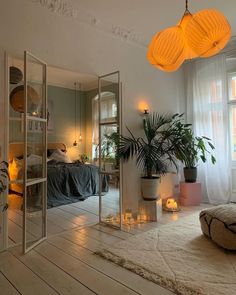 a living room filled with furniture next to a window and potted plants on top of a rug