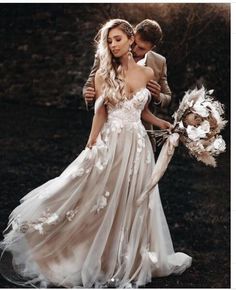 a man and woman in wedding clothes standing next to each other with flowers on them