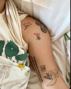 a woman laying in bed with tattoos on her arm