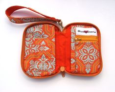 an orange and white purse with two zippers on the inside is open to show it's contents