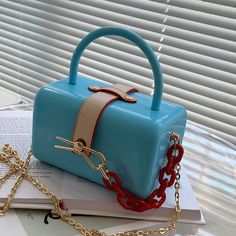 a blue purse sitting on top of a book