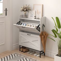 a white shoe rack with shoes and umbrellas on it in front of a door