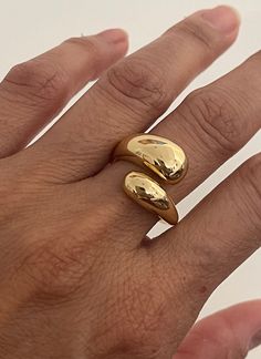 a person's hand with two gold rings on it