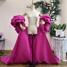 a mannequin wearing a pink gown with ruffled sleeves