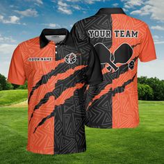 an orange and black polo shirt with the words your team on it, in front of a green field