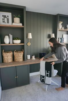 a home office with green painted walls and shelves