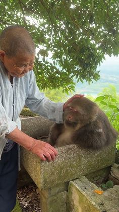 an older man petting a monkey on the head