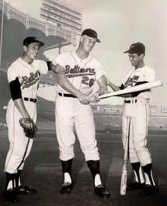 three baseball players are holding bats in their hands and posing for a photo on the field