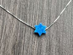 This beautiful Star of David /Magen David/Jewish Star Opal Necklace is sure to be someone's favorite. It's a great Bat Mitzvah or Hanukkah gift. Sterling Silver or 14kt Gold Filled Charm Size: 10mm Lab Created Opal Your Choice of Length and Color Chain Styles: 0.7mm Box Chain Disclaimer: Before placing an order for a necklace or bracelet, please ensure you measure your desired size carefully. Customers are fully responsible for choosing the correct length, as all cut chains are non-refundable. I Blue Star Shaped Necklace For Gift, Blue Star Of David Necklace As Gift, Blue Star Of David Necklace For Gift, Blue Necklace With Star Charm As A Gift, Blue Star Of David Necklace Gift, Blue Star Charm Necklace As A Gift, Blue Star Charm Necklace As Gift, Blue Star Charm Necklace For Gift, Blue Sterling Silver Star Of David Necklace