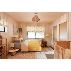 a bedroom with striped walls and yellow bedding