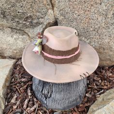 "The Mae is pretty in pink... with beige tones. Simple and pretty is The Mae! Handmade Fedora hats with Western style bling. All hats are ONE OF A KIND and designed personally by myself. Purposely aged to add lots of character! I enjoy creating unique items for others to enjoy in this mass produced world. Be UNIQUE... stand out in the crowd!  All hats are made to fit differently- this hat measures about 23\" with a tie to make adjustments allowing you to tighten the fit." Pink Brimmed Hat One Size, Pink Adjustable Fedora Felt Hat, Adjustable Pink Fedora Felt Hat, Pink Adjustable Fedora With Curved Brim, Adjustable Pink Fedora With Curved Brim, Pink Wide Brim Costume Hat For Festival, Pink Adjustable Curved Brim Fedora, Pink Fedora With Curved Brim, Adjustable Pink Brimmed Fedora