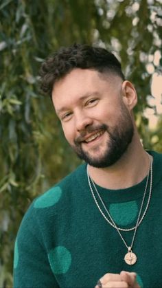 a man with a beard wearing a green sweater