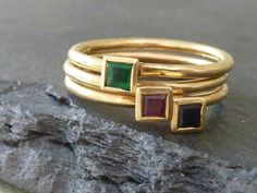 Three 18ct yellow gold rings that stack very neatly together. They are all made in hallmarked 18ct yellow gold and are set with a ruby, emerald and sapphire. Each stone is 3mm square and each band 1.5mm round . They can be made to your size in 1-2 weeks, just leave your details at the checkout. This is a special offer price for all three rings.I can ship these rings by Fed-ex if required at a charge of $30. Otherwise FREE SHIPPINGRuby is  the July birthstone, Sapphire is September and Emerald is Gold Emerald Ring Stackable Fine Jewelry, Gold Emerald Cut Stackable Birthstone Ring, Gold Stackable Birthstone Ring With Emerald Cut, Stackable Gold Emerald Cut Rings, Stackable Yellow Gold Emerald Birthstone Ring, Yellow Gold Stackable Emerald Birthstone Ring, Yellow Gold Emerald Birthstone Stackable Ring, Yellow Gold Emerald Birthstone Ring Stackable, Gold Stackable Emerald Ring