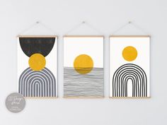 three art prints hanging on the wall in front of a white wall with an orange circle