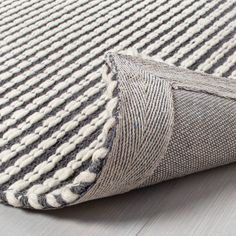 a close up of a rug on the floor with white and black stripes in it