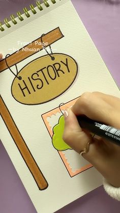 a person holding a marker and writing on a piece of paper with the word history