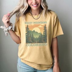 Explore in style with this Vintage Rocky Mountains Colorado T-Shirt. Perfect for the outdoor enthusiast, this graphic tee features a beautiful sun-soaked landscape of the Rocky Mountains that will inspire your next adventure. Made with soft, breathable fabric, it's ideal for both hikes and casual wear. Unisex sizing makes it a great fit for anyone, while the stunning design serves as a charming gift for travelers or nature lovers. Please remember to wash inside out and tumble dry, do not use ble Graphic Tee With Relaxed Fit For Outdoor Activities, Relaxed Fit Graphic Tee For Outdoor Activities, Relaxed Fit Graphic Print T-shirt For Outdoor Activities, Relaxed Fit Graphic Tee For Hiking, Graphic Print Relaxed Fit Top For Hiking, Relaxed Fit Graphic Print Top For Hiking, Summer Hiking T-shirt With Screen Print, Outdoor Graphic Tee With Screen Print, Graphic Tee For Hiking With Relaxed Fit