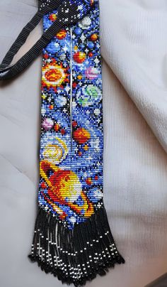 the beaded tie is decorated with an image of planets and stars on it's side