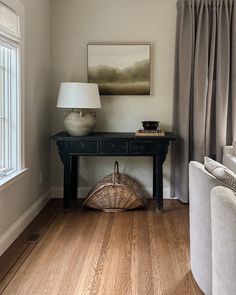 a living room with wood floors and white furniture