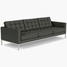 a black leather couch sitting on top of a white floor