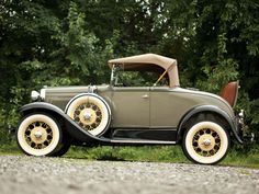 an antique car parked on the side of a road