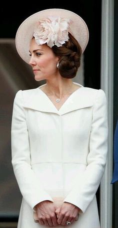 the duke and princess of cambridge look on as they stand next to each other in white outfits