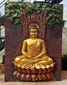 a golden buddha statue sitting in front of a tree