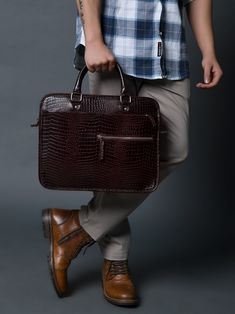 Indulge in trend with our Croco Leather Computer Bag. Made of premium full grain buffalo leather, this dark brown laptop bag features an elegant croco pattern that is perfect for your everyday work and wear. Keep your computer protected in style, and make a statement with this exclusive piece. Salient features: Handcrafted with full grain buffalo leather Color dark brown on textured leather Sleek and minimalistic look One main compartment to carry all your essentials Small zippered pocket in fro Classic Crocodile Pattern Shoulder Bag For Work, Leather Shoulder Bag With Crocodile Pattern For Business, Business Leather Shoulder Bag With Crocodile Pattern, Brown Crocodile Pattern Shoulder Bag For Business, Leather Bags With Crocodile Pattern For Business, Business Leather Bags With Crocodile Pattern, Business Brown Crocodile Pattern Bag, Brown Textured Leather Briefcase For Work, Luxury Brown Shoulder Bag With Laptop Sleeve