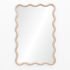 a mirror with scalloped edges on a white wall