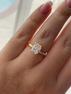 a woman's hand with a yellow and white diamond ring on top of it