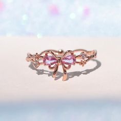 This ring will get you feeling extra pretty in pink! Wrap yourself up in a bow and celebrate the greatest present there is--you! Featuring a delicate intertwining band and dazzling embellishments, all leading to a perfect pink ribbon. This piece will make you feel like the ultimate gift! 18k gold plated, 18k rose gold Pink Ribbon Jewelry As Gift, Pink Ribbon Jewelry Gift, Gift Jewelry With Pink Bow, Pink Ribbon Jewelry For Gifts, Valentine's Day Gift Jewelry With Pink Bow, Rose Gold Jewelry With Bow For Gifts, Pink Bow Jewelry For Anniversary, Pink Ribbon Jewelry For Party, Pink Bow Jewelry For Valentine's Day Party