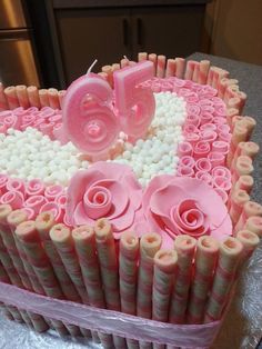 a heart shaped cake with pink icing and flowers