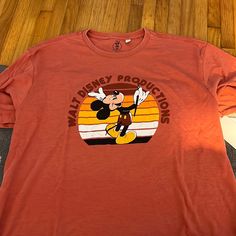 an orange shirt with mickey mouse on it