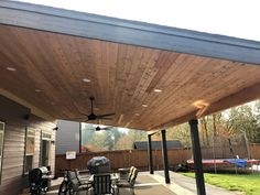 an outdoor covered patio with grill and table