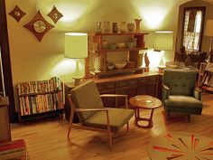 a living room filled with lots of furniture and bookshelves on top of hard wood floors