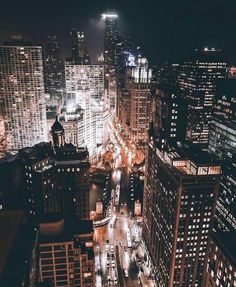 an aerial view of a city at night with lots of tall buildings and street lights