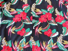 a black floral print shirt with red flowers and green leaves