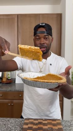 a man holding a piece of pie on top of a pan in front of his face