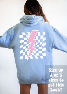 a woman wearing a blue hoodie with a lightning bolt printed on the front and back